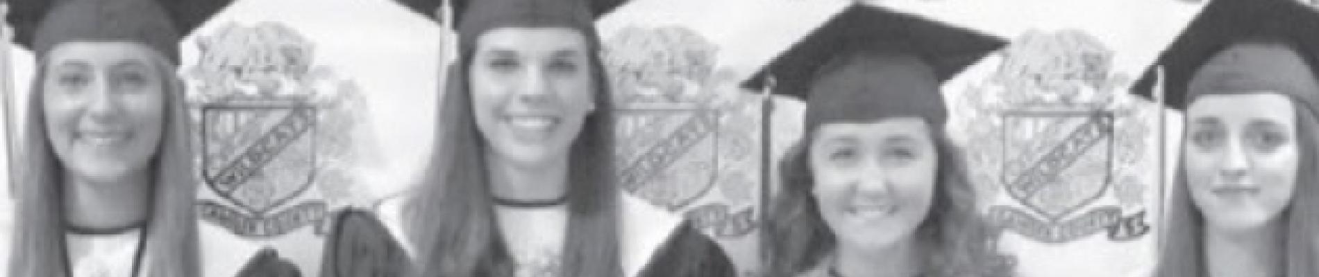 Graduates in caps and gowns hold diplomas, smiling in a black-and-white photograph.